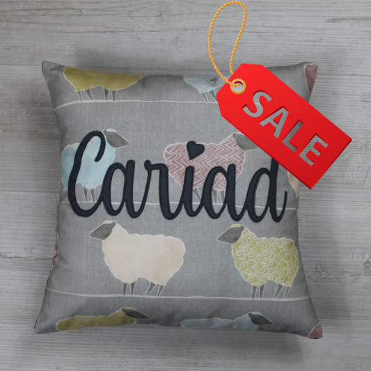 Handmade Welsh ‘Cariad ’ cushion  in pink on a 100% cotton sheep-pattern fabric