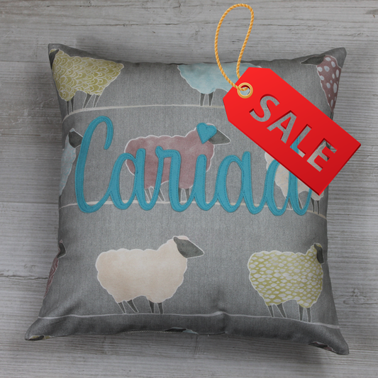 Handmade Welsh ‘Cariad ’ cushion  in pink on a 100% cotton sheep-pattern fabric