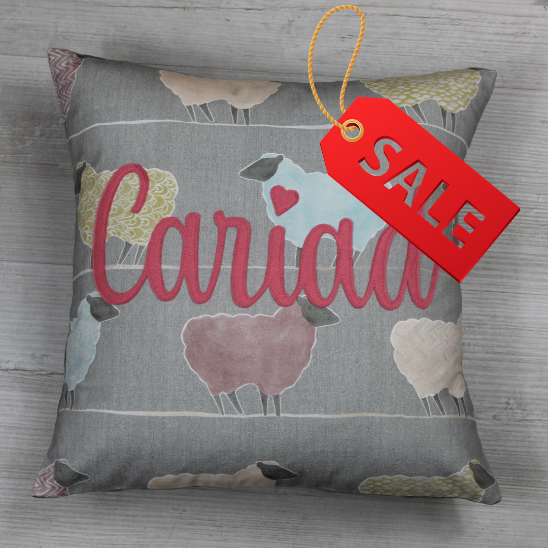 Handmade Welsh ‘Cariad ’ cushion  in pink on a 100% cotton sheep-pattern fabric