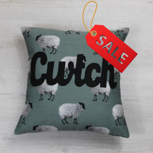 Cwtch Cushion on a beautiful teal tapestry style fabric 